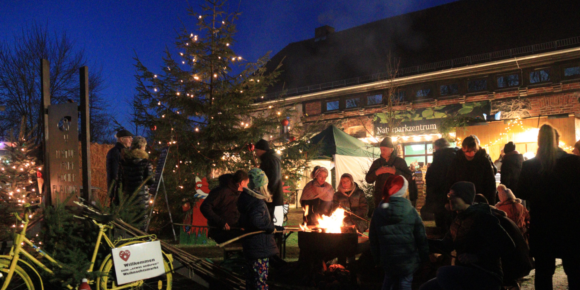Gruppe an einer Feuerschale auf dem Weihnachtsmarkt