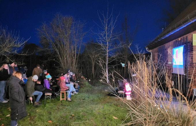 Menschen vor einer hellen Kino-Leinwand